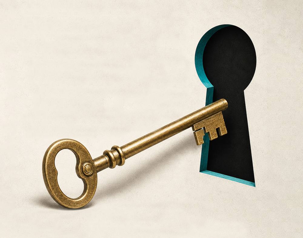 A brass skeleton key resting in front of a keyhole cut into paper